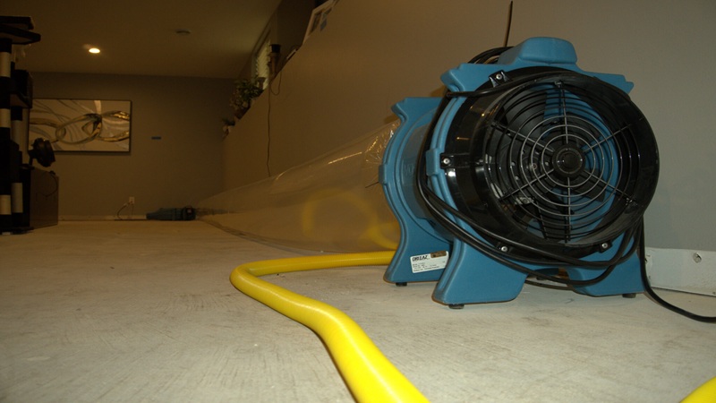 Professional water damage drying equipment used during emergency water restoration service in a flooded basement area.